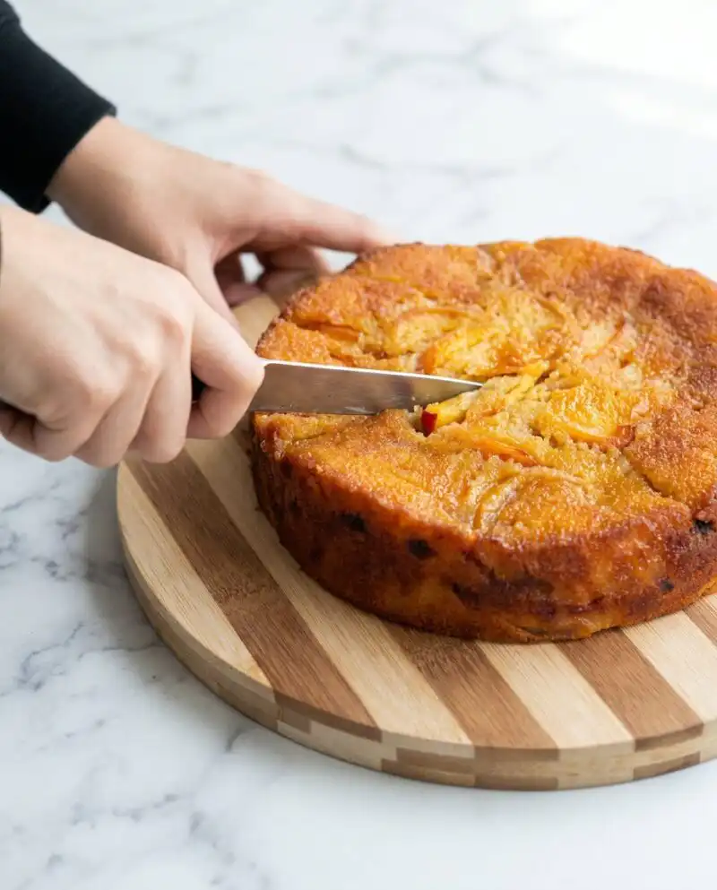 A Brown Butter Fresh Peach Cake in a square baking pan with a thick crumb topping.