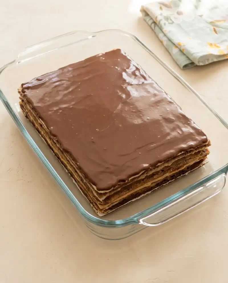 A close up shot of a sliced Opera Cake showing six distinct layers of sponge and buttercream.