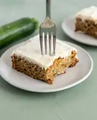 A square slice of Classic Zucchini Cake with Cream Cheese Frosting showing the tender crumb.
