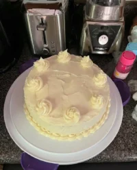 A stunning Lemon Velvet Cake with cream cheese frosting on a white cake stand