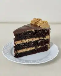 A tall dark chocolate peanut butter cake with chocolate ganache drips
