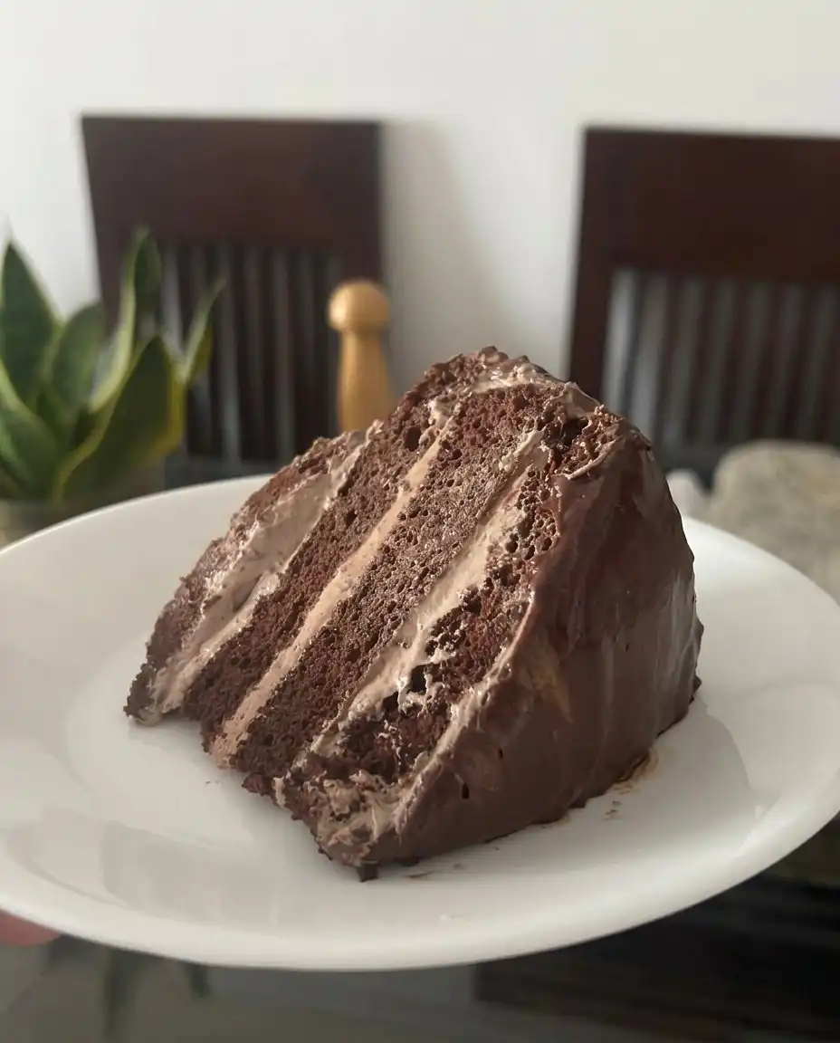 Chocolate Mousse Cake 13 A hand gently folding chocolate whipped cream into a pudding base with a rubber spatula.