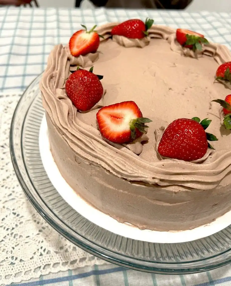 Strawberry Chocolate Cake 14 A piping bag creating a frosting ring on a chocolate cake layer