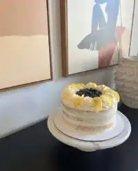 A thick slice of Lemon Blueberry Cake showing the purple filling and yellow layers