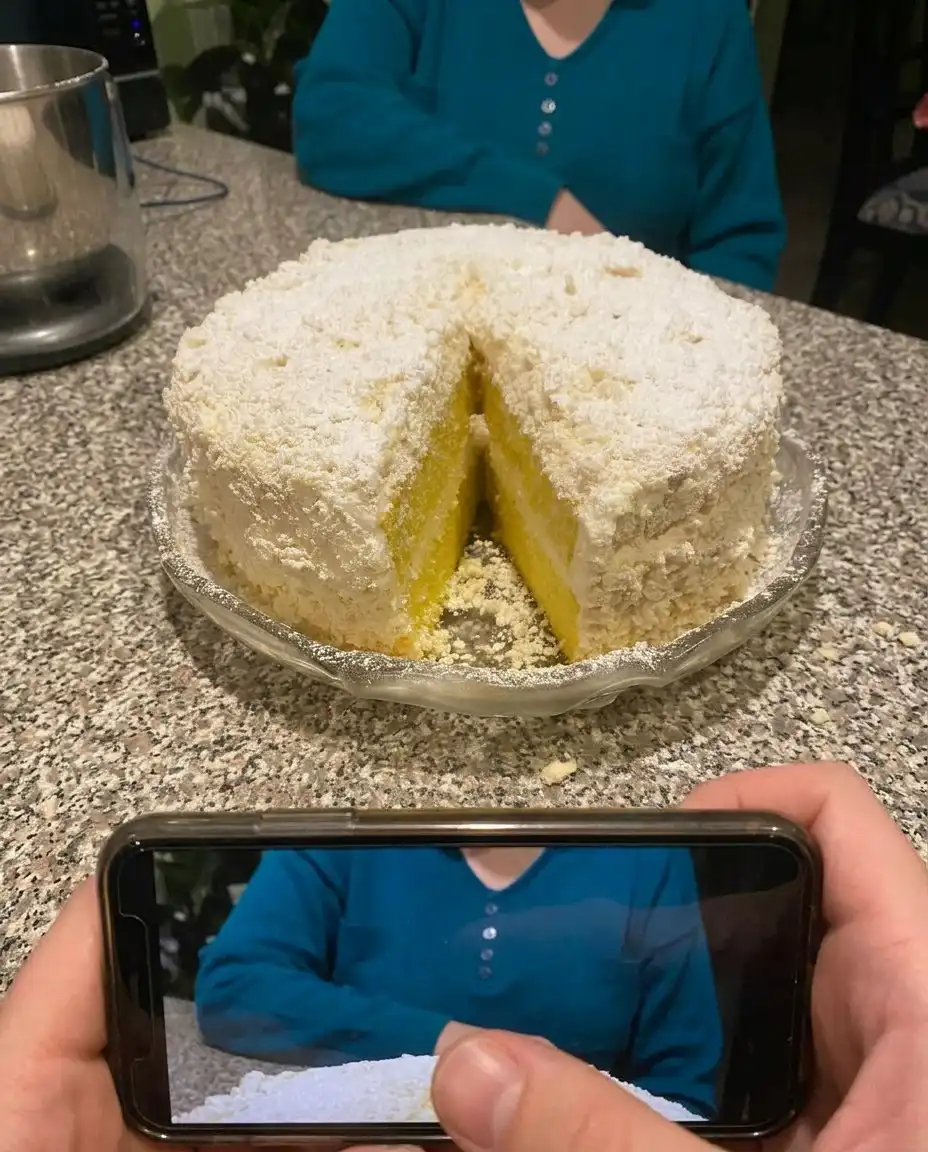 Whole Italian Lemon Cream Cake topped with white chocolate curls and zest