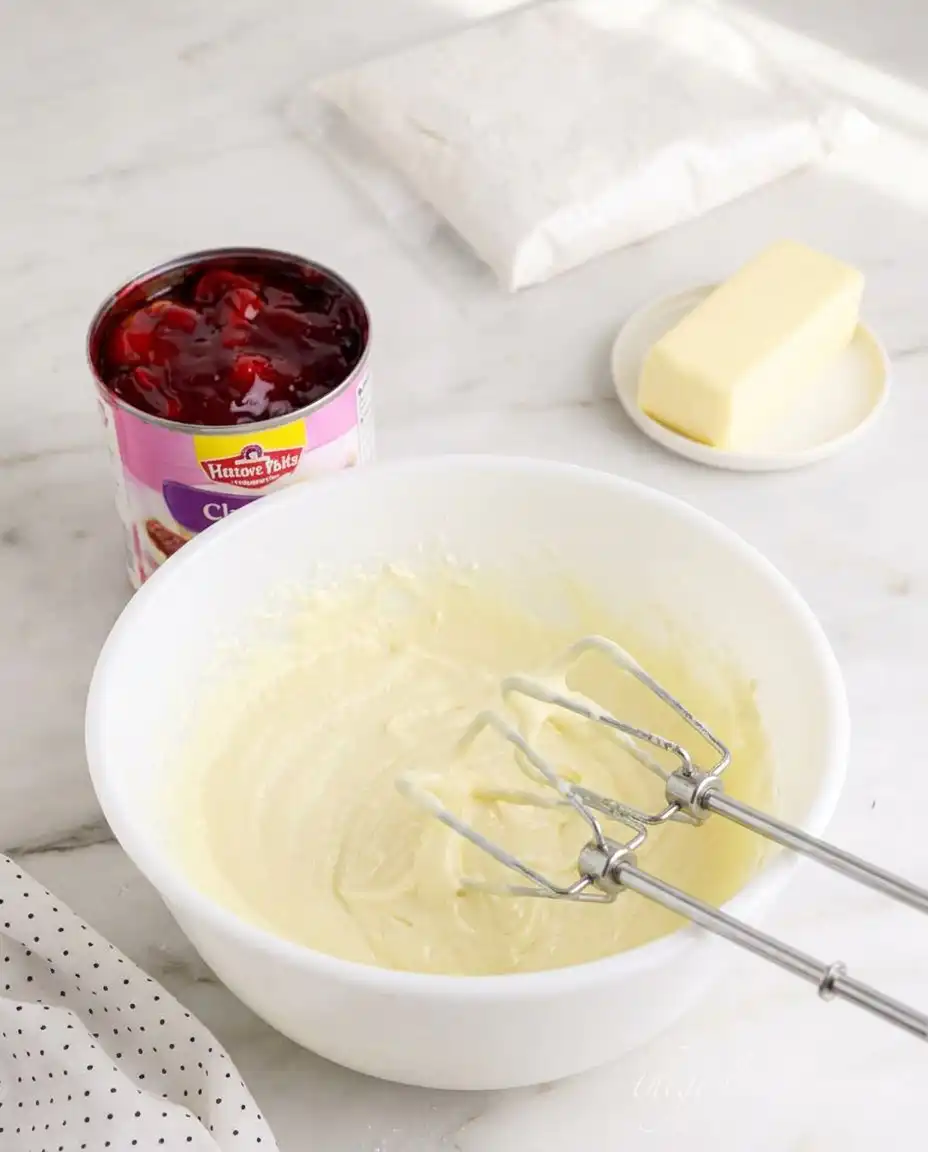 Melted butter being poured over dry yellow cake mix