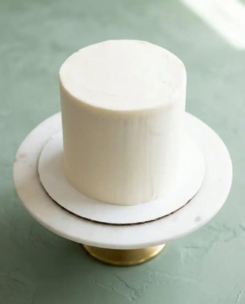 A beautiful three layer Mini Vanilla Layer Cakes decorated with white buttercream and sprinkles.
