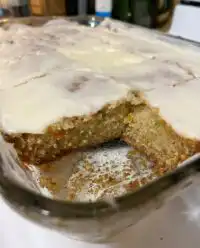 A close up of sliced moist zucchini bars with thick caramel frosting on a cooling rack