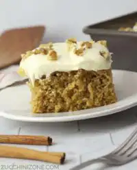 A moist slice of Zucchini Spice Cake with Cream Cheese Frosting on a plate with a fork