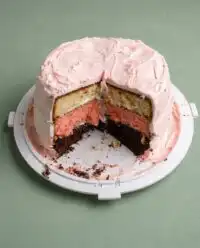A Neapolitan Anniversary Cake with three layers of frosting and a chocolate ganache drip.