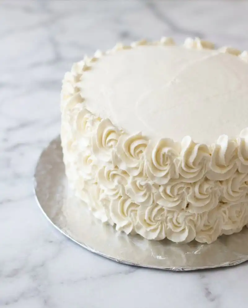 A rustic Peach Buttercream Birthday Cake with hand-piped rosettes and soft peach hues.