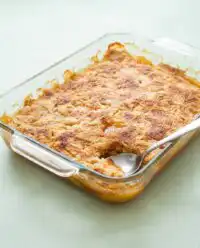 A golden brown Peach Cobbler with Yellow Cake Mix bubbling in a glass baking dish.