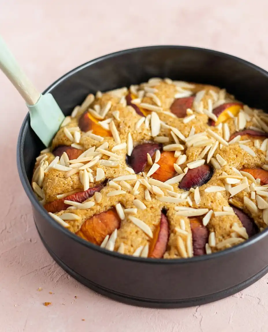 Sour Cream Peach Coffee Cake 16 A thick slice of Sour Cream Peach Coffee Cake on a plain white plate with a fork.