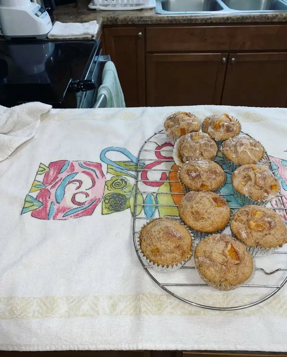 Muffins on a wooden board next to a glass of iced sweet tea