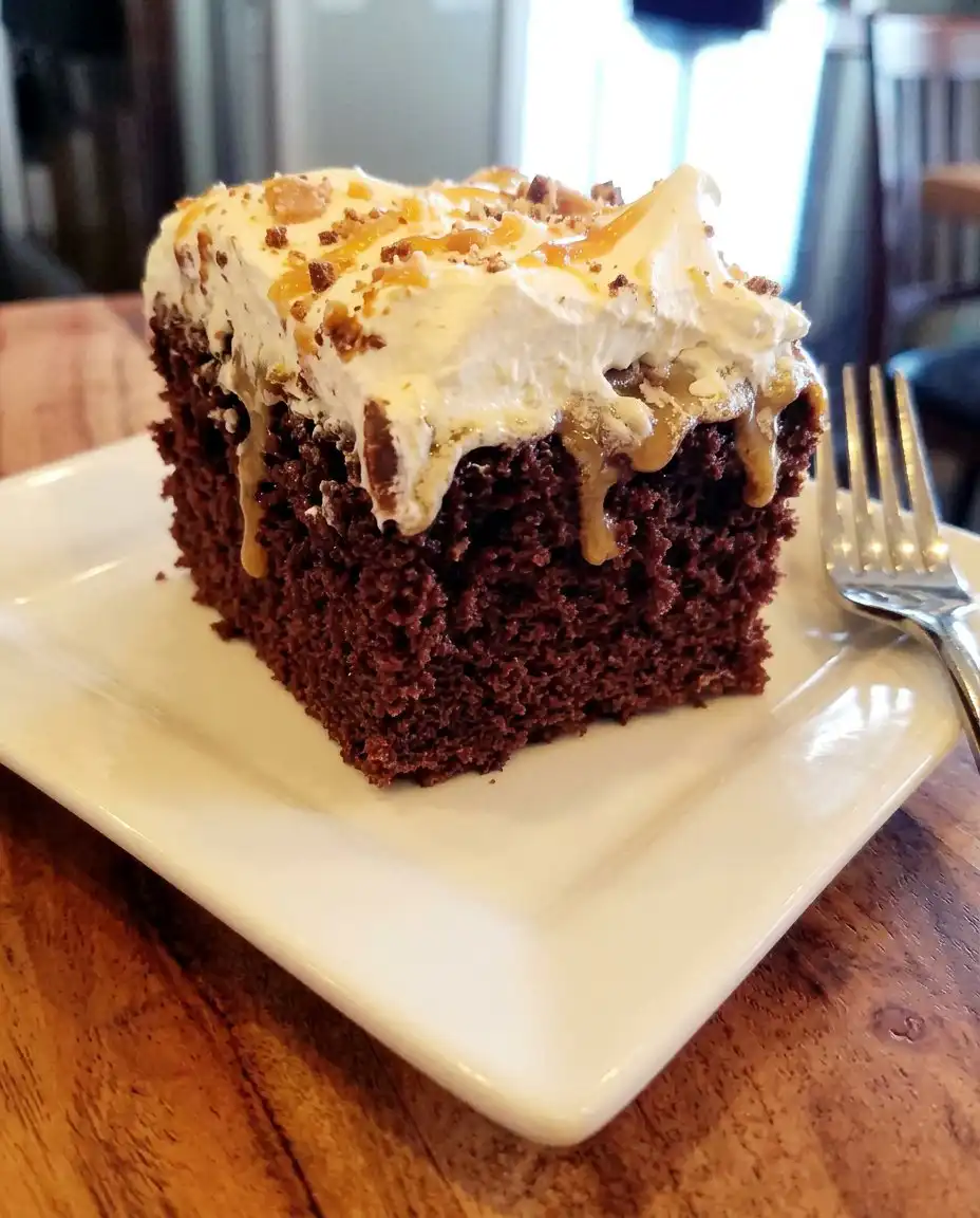 A wooden spoon handle being used to poke holes into a baked chocolate cake.