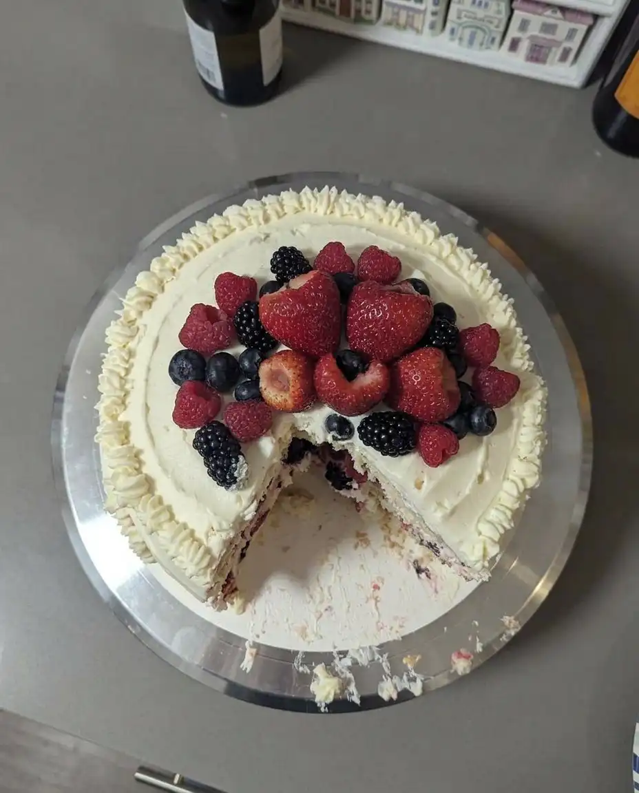 Overhead view of precisely measured ingredients including cake flour, frozen berries, and heavy cream