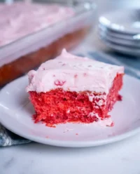 A beautiful pink raspberry fluff cake in a baking pan with whipped cream icing