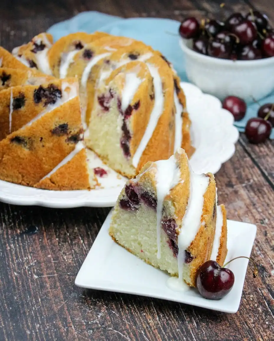 Cherry Amaretto Bundt Cake 10 A golden Cherry Amaretto Bundt Cake sitting on a rustic wooden farmhouse table.