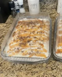 A rustic chocolate caramel toffee crunch cake in a baking pan with toffee bits on top.