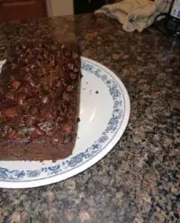 A rustic loaf of chocolate zucchini bread sitting on a wooden board