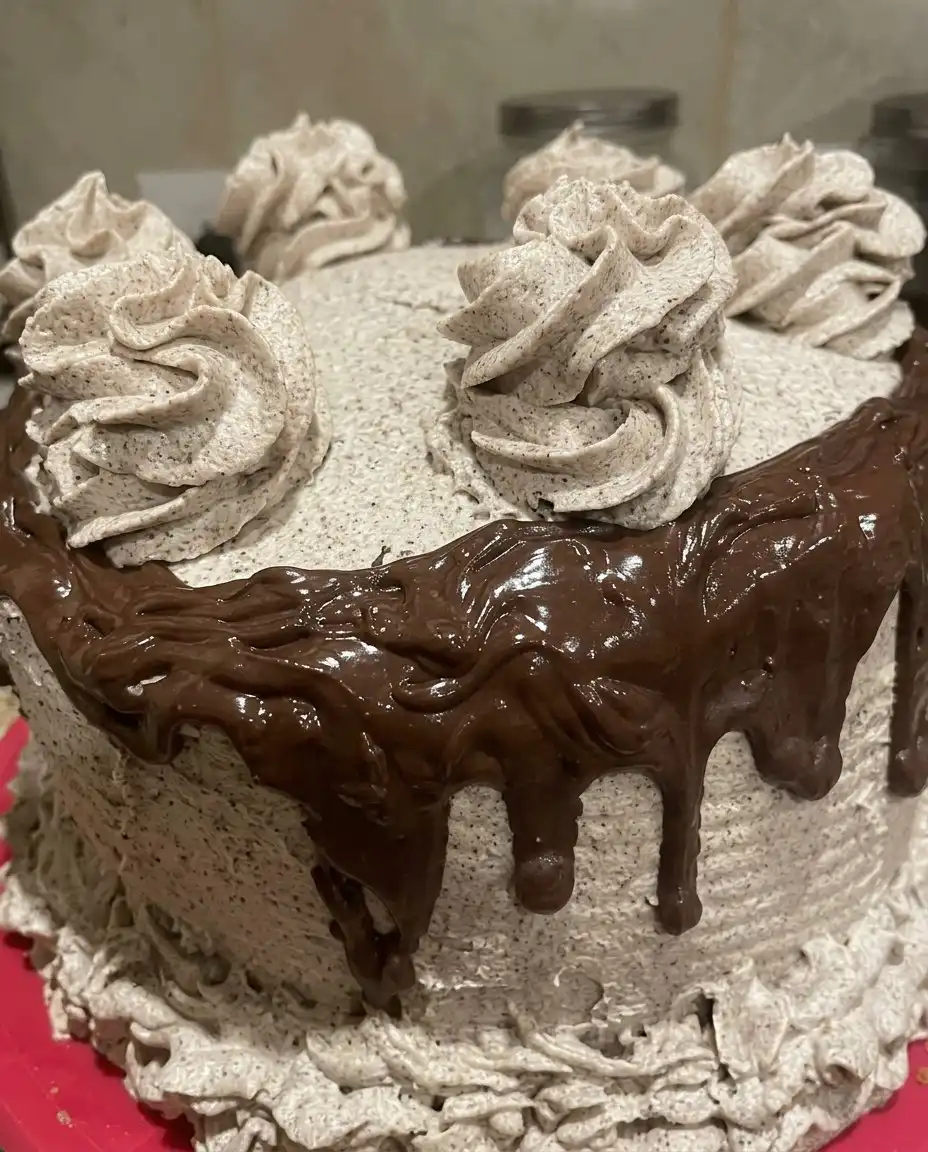 The Softest Oreo (Cookies & Cream) Cake 10 A soft Oreo cookies and cream cake sitting on a rustic wooden farmhouse table.