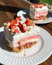 A rustic square dish of No-Bake Strawberry Dream topped with fresh sliced strawberries.