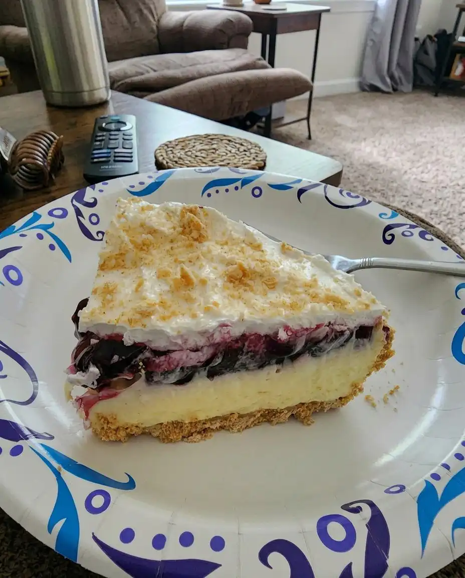 A single slice of lemon blueberry dessert on a white ceramic plate with a sprig of mint