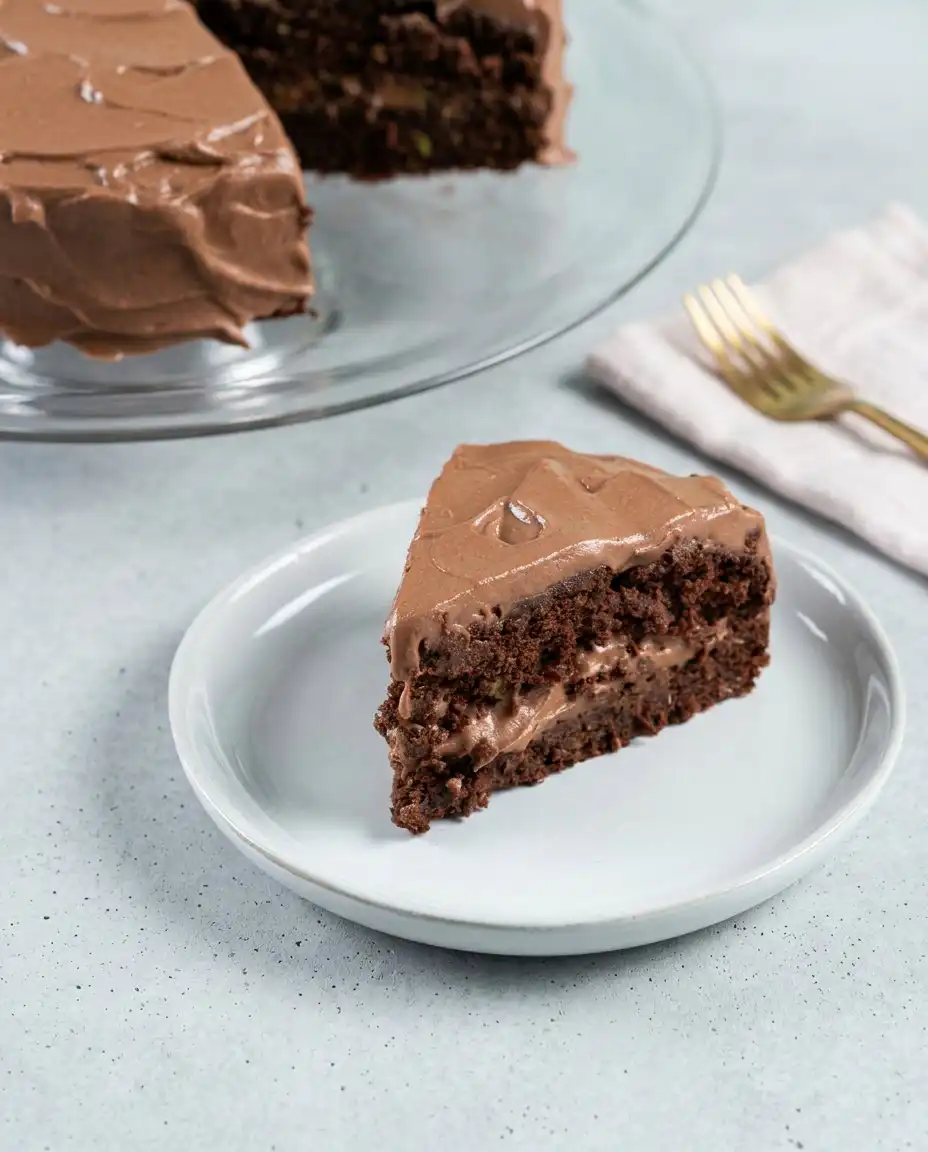 Dairy-Free Chocolate Zucchini Cake 16 A single slice of Dairy-Free Chocolate Zucchini Cake on a vintage plate with a fork.