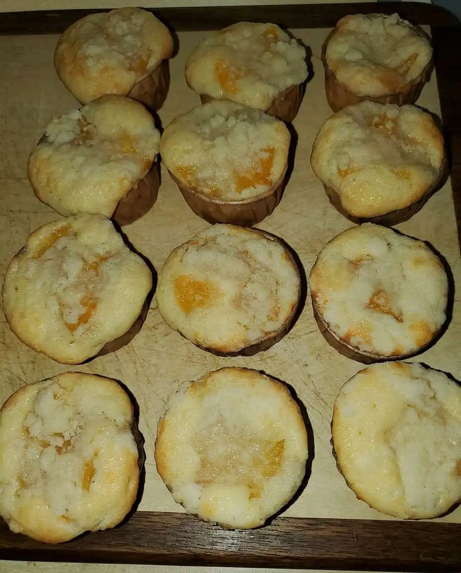 Peach cobbler muffins served on a vintage plate with a cup of coffee.