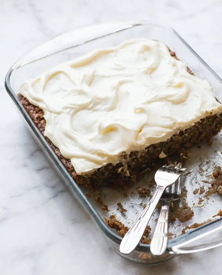 Old-Fashioned Zucchini Cake 16 Two slices of Old-Fashioned Zucchini Cake on a white plate with a side of fresh walnuts.