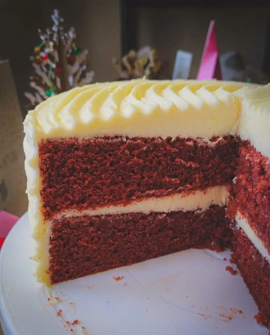 Red Velvet Cake 14 A single slice of red velvet cake showing the moist red crumb and layers of frosting.