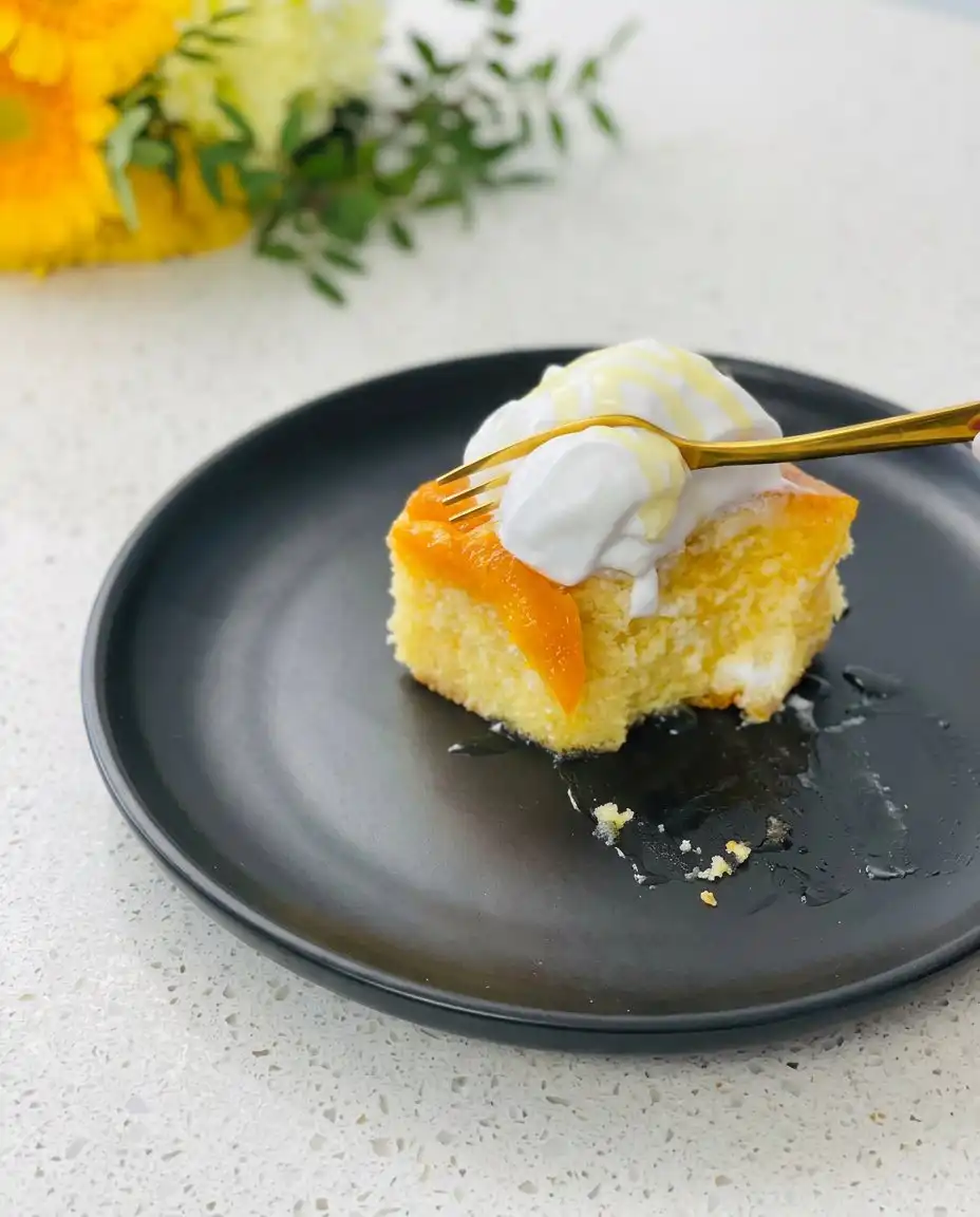 A single slice of Brown Sugar Peach Upside Down Cake served on a white porcelain plate.