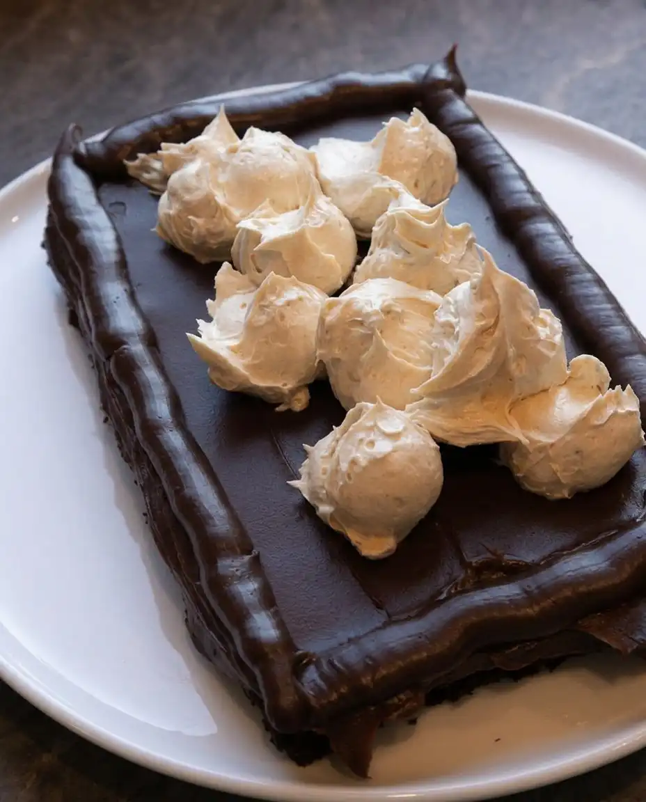 Peanut Butter Fudge Cake 14 A single slice of Peanut Butter Fudge Cake on a wooden plate