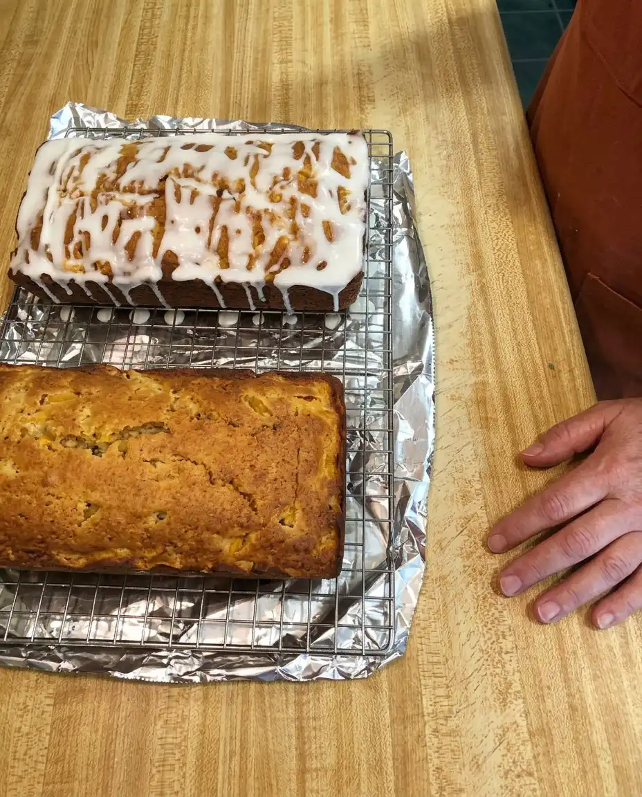 Slicing a moist loaf of Heavenly Peach Bread on a wooden board