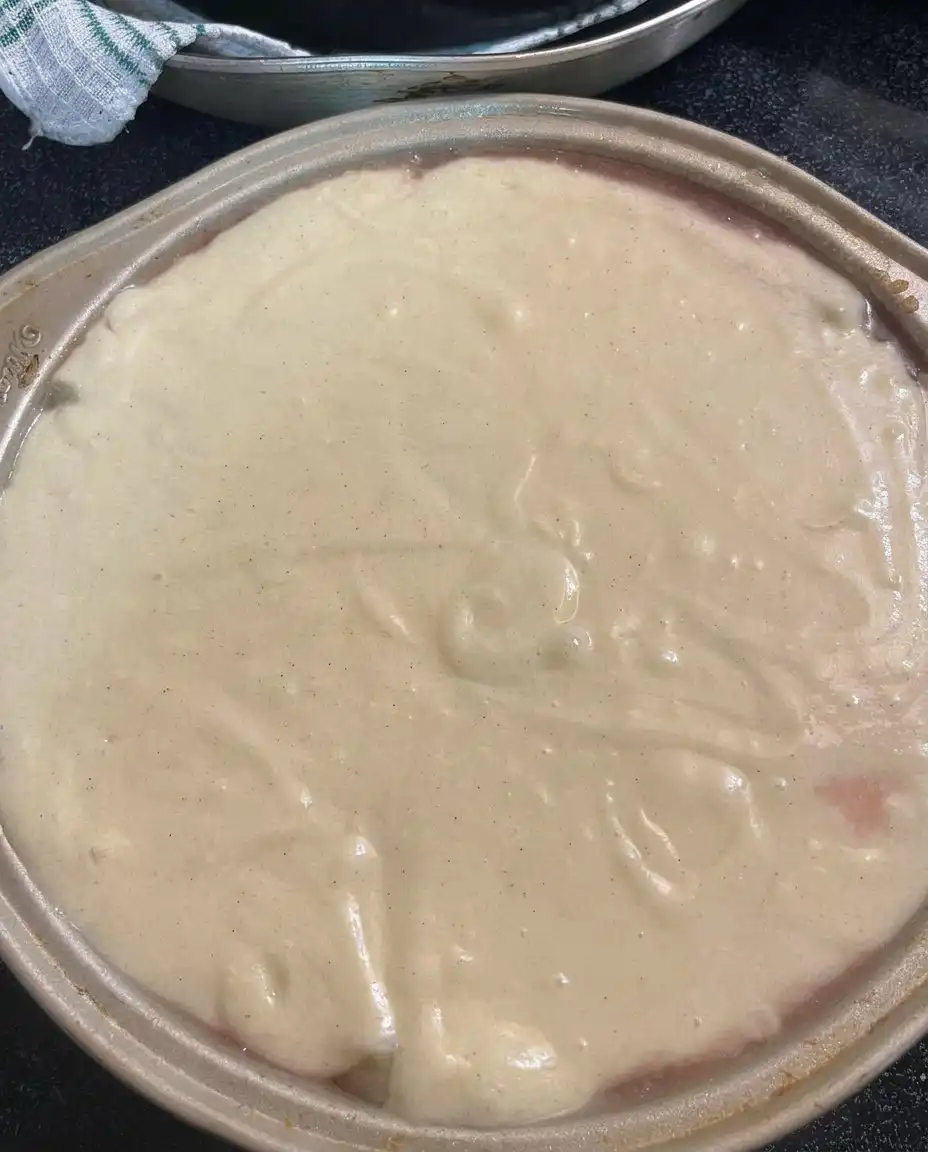 A sharp knife slicing through a moist pineapple layer cake with visible fruit pieces