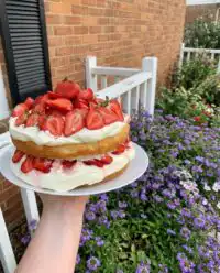 A close up shot of a sliced Strawberry Shortcake Layer Cake showing the sponge and mascarpone cream layers