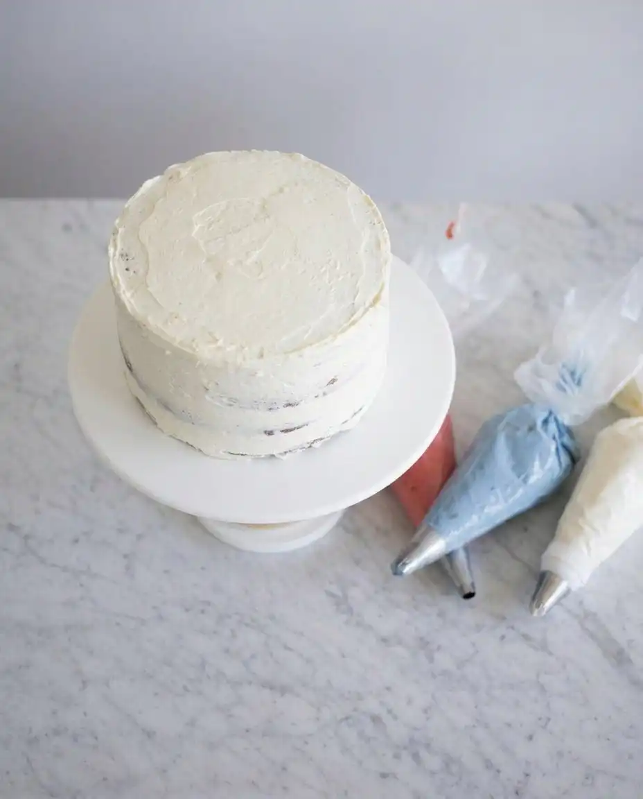 American Flag Cake 13 Close up of glossy Swiss meringue buttercream being lifted with a spatula to show a silky stable texture.