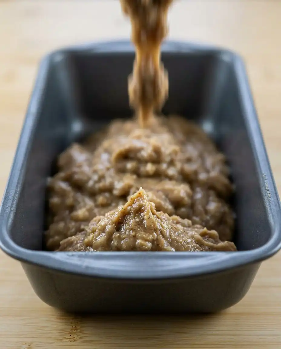 An instant read thermometer being used to check the center of apple zucchini bread.