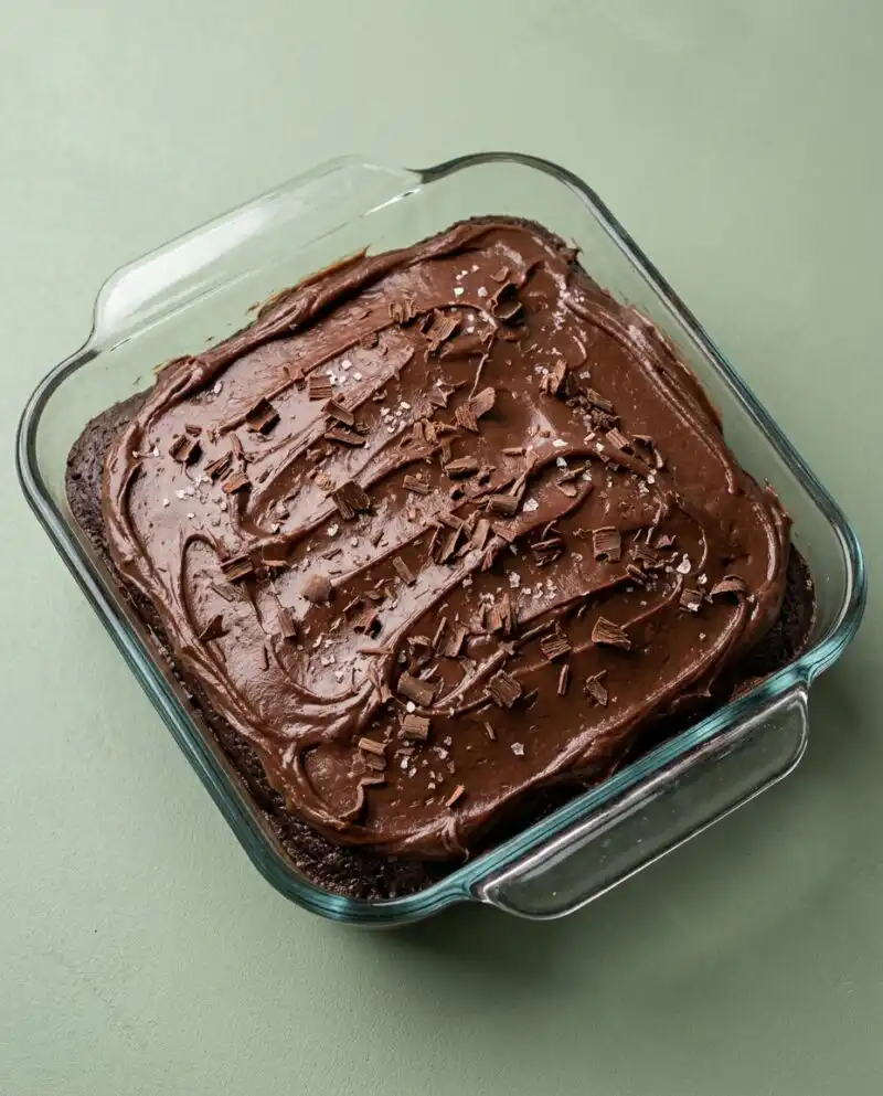 A moist slice of Vegan Chocolate Zucchini Cake resting on brown parchment paper.