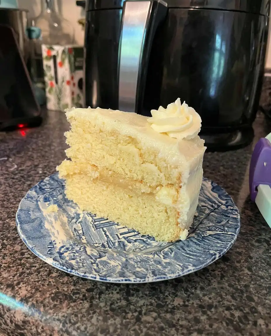 Smooth yellow cake batter being mixed in a glass bowl