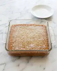 A slice of Zucchini cake with lemon glaze showing a moist interior and golden edges.
