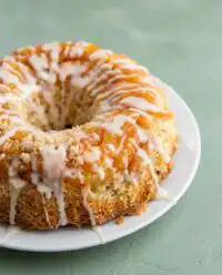 A golden buttery peach cobbler pound cake on a wire cooling rack after baking.