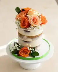 A stunning rustic Naked Cake with Fall Flowers displayed on a dark wooden table