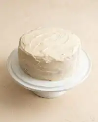 Slices of Pumpkin Spice Layer Cake with Cinnamon Cream Cheese Frosting on a glass stand.