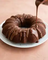 A rustic healthy chocolate zucchini cake sliced on a wooden table