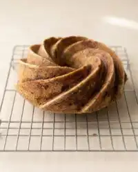 A warm rustic spiced pear cake cooling on a farmhouse windowsill during autumn