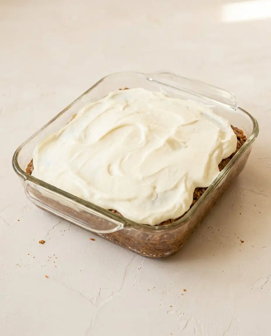 A slice of Pineapple Sheet Cake with Cream Cheese Frosting served on a plain white plate
