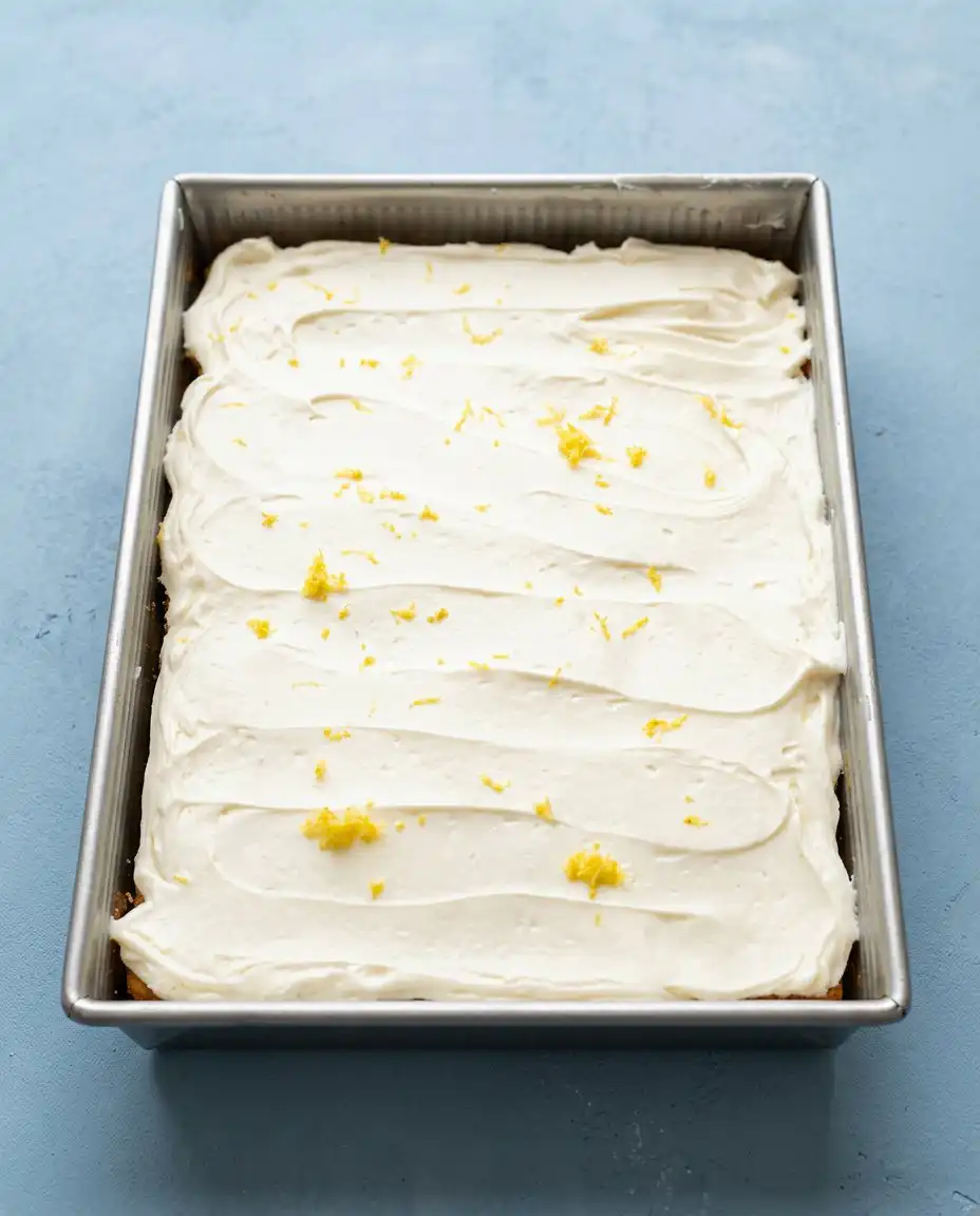 A slice of Zucchini Cake with lemon cream cheese frosting sitting on an ideal heritage china plate.